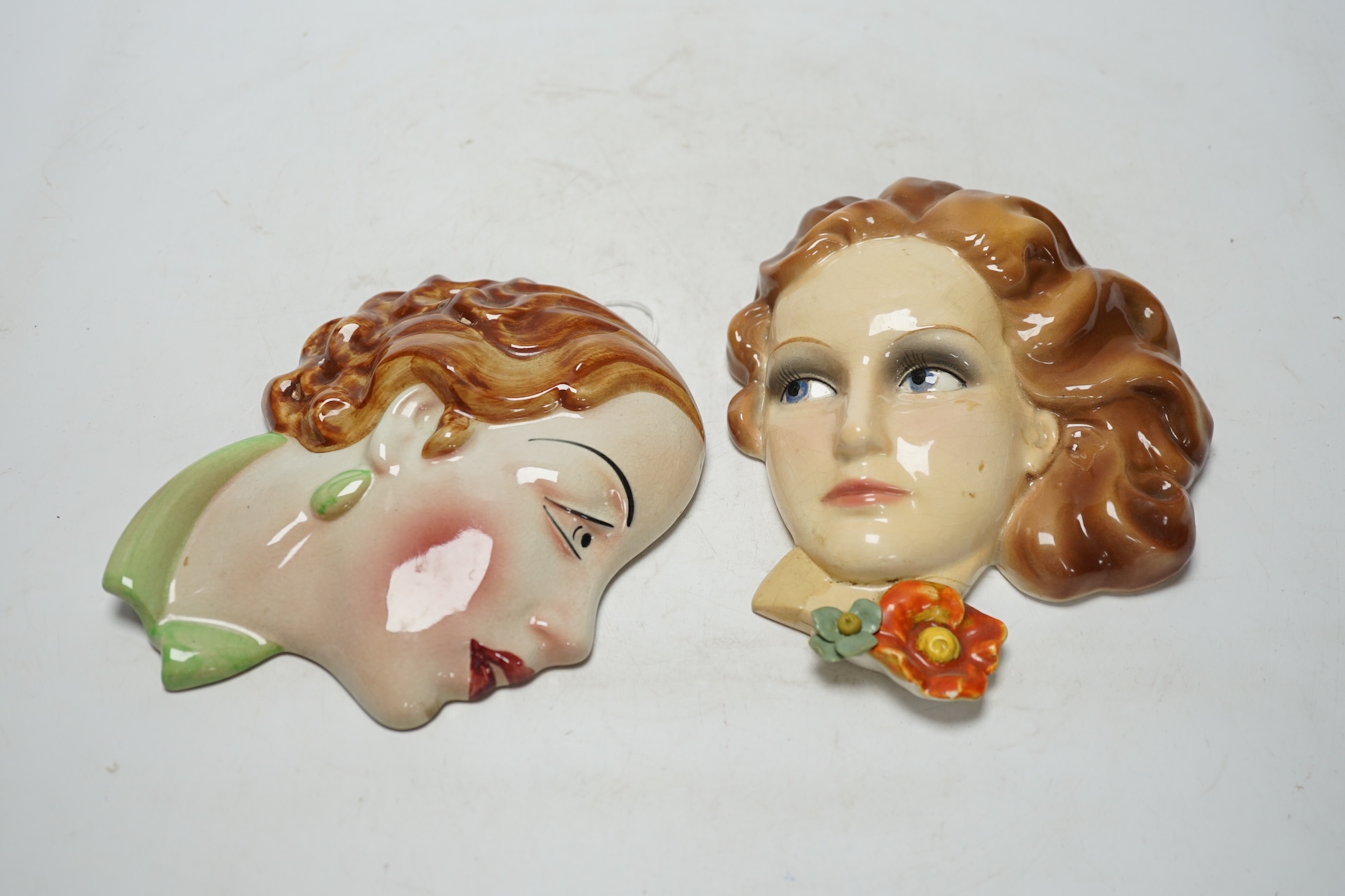 From the Studio of Fred Cuming. Two pottery wall masks including a Copes & Co. Art Deco example, largest 17cm high. Condition - Copes & Co. good, other poor